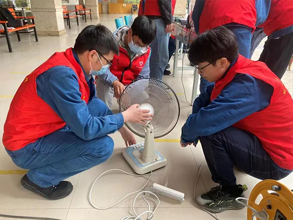Employees assisting residents with appliance repairs