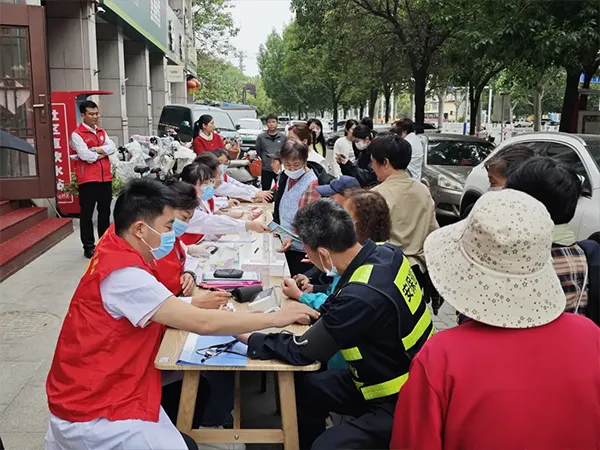Employees assisting residents with blood pressure measurement