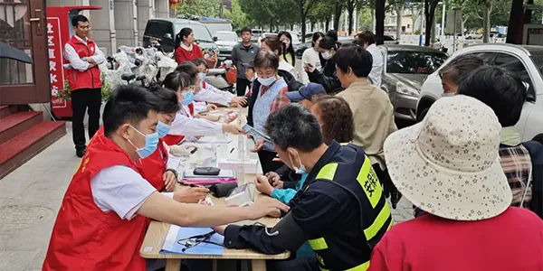 Employees assisting residents with blood pressure measurement